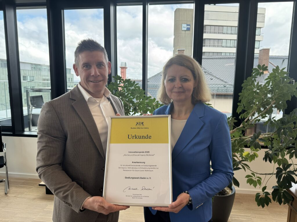 v.l.n.r. Marc Ullrich, Vorstand Siedlungswerk Baden e.V. und Dana Mebus, Vorsitzende Stiftungsvorständin der Stiftungen der Erzdiözese Freiburg freuen sich über die Urkunde des Landes Baden-Württemberg.